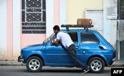 Un hombre empuja un automóvil cerca de una gasolinera en La Habana el 11 de diciembre de 2024. YAMIL LAGE / AFP