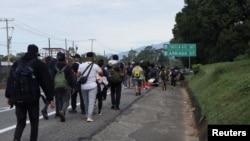 Migrantes caminan en caravana en un intento por llegar a la frontera con Estados Unidos, en Tapachula